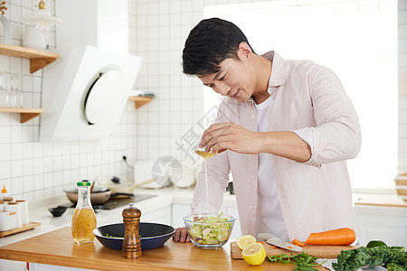 年轻男性做饭年轻男子在厨房制作沙拉背景