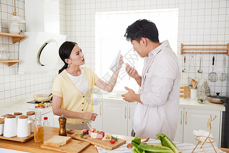 年轻情侣在厨房因为账单而争吵图片