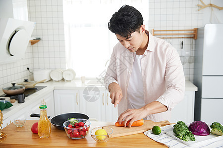 年轻的男人在厨房做饭背景图片