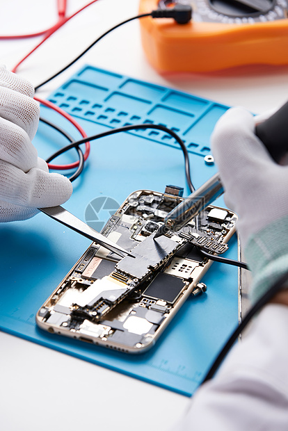 戴绝缘手套的维修工在修智能手机