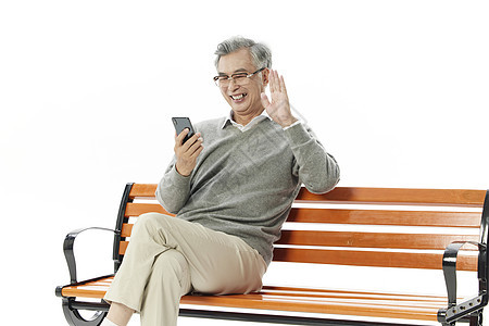 老年人坐在长椅上手机视频通话打招呼图片