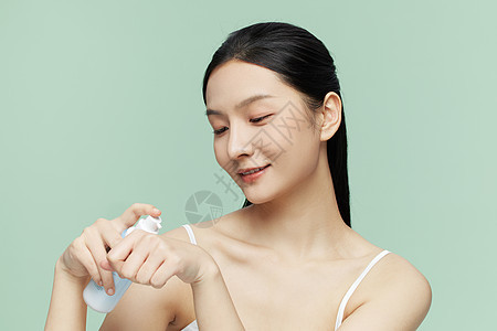 女性使用乳液护肤背景图片