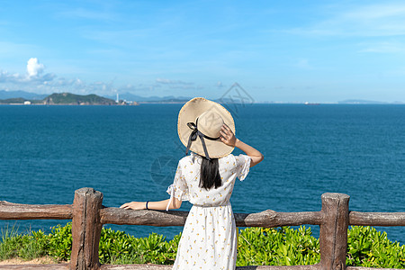 度假旅行美女海边山上的少女背影背景