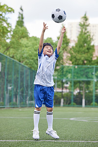 小男孩用手接住足球图片