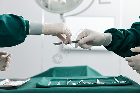 外科医生传递手术刀特写图片