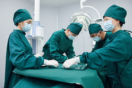 手术室里忙碌的外科医生团队背景图片