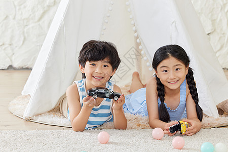 两个小朋友在帐篷里玩汽车模型图片
