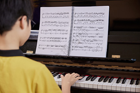 儿童学生学习弹奏钢琴曲背景图片