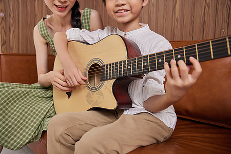 音乐教师教儿童弹奏吉他特写图片