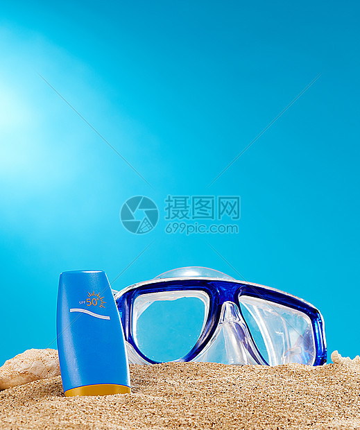 夏日沙滩上的防晒霜和防护镜图片