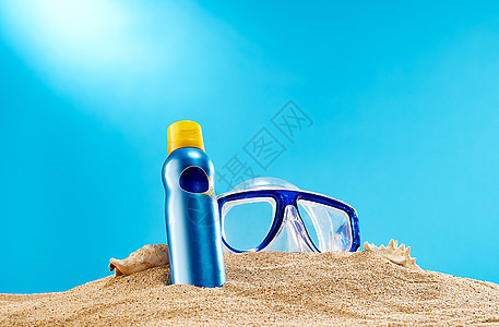 夏日沙滩上的防晒霜和防护镜图片