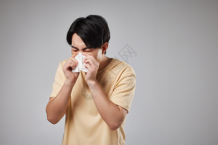 年轻男性用纸巾擦鼻涕图片