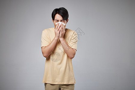 年轻男性用纸巾擦鼻涕图片