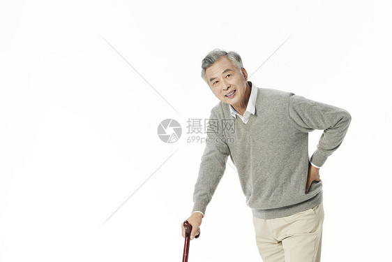 老年男性拄着拐杖行走图片