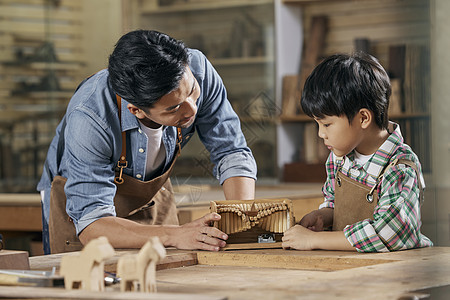 男木匠师傅和小男孩讲解手工音乐盒制作背景图片
