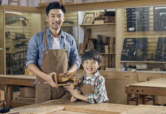 木工老师和小男孩展示木制手工作品图片