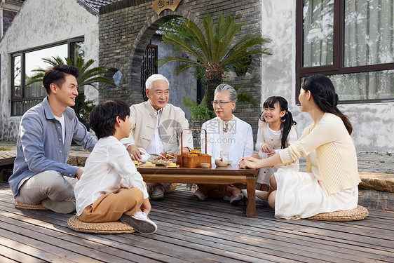 一家人庭院里相聚过中秋节吃月饼图片