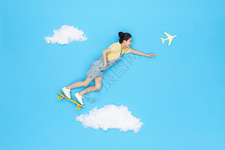 创意俯拍美女云朵上踩滑板飞行旅行图片