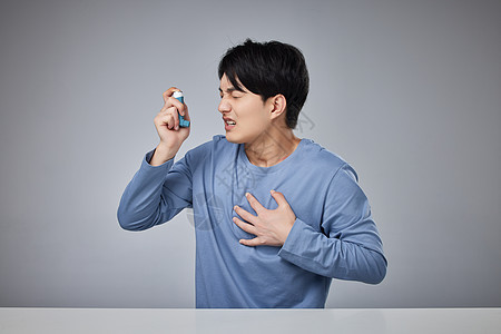 年轻男性使用哮喘吸入器图片