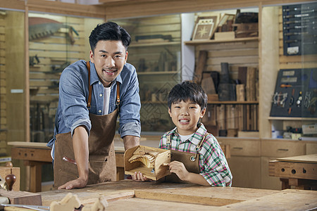 木工老师和小男孩展示木制手工作品图片
