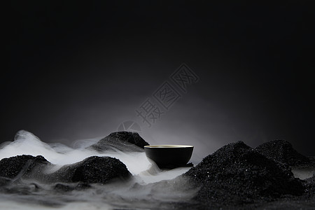 黑色背景下的干冰和茶杯图片