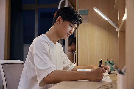 写功课夜里认真写作业的男大学生背景