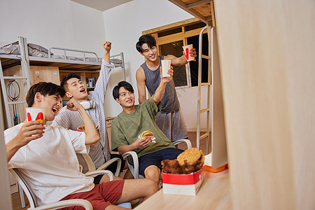 宿舍庆祝球赛胜利的男大学生背景图片