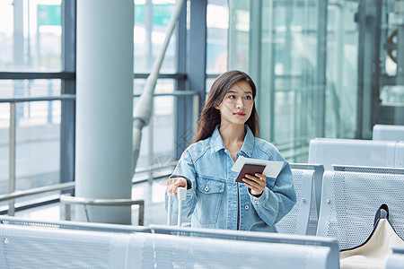 旅游出行的年轻女性手拿机票和护照图片