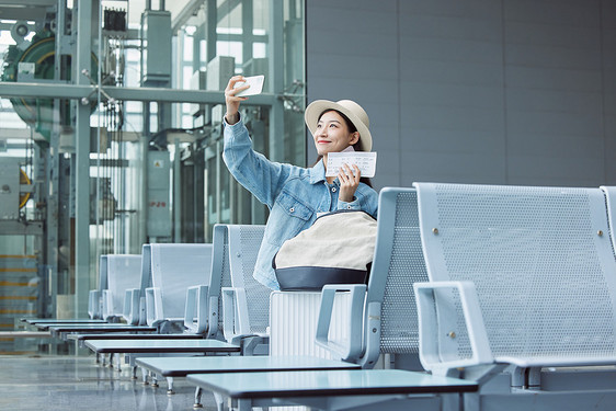 旅行的女性在机场候机厅等候图片