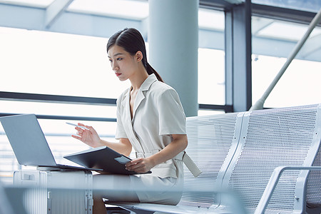 办公电话出差女性在机场办公背景