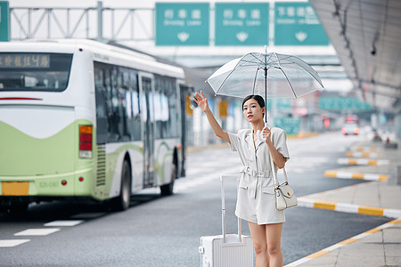撑着伞在路边打车的商务女性图片