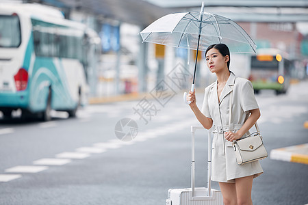 雨天在路边焦急等车的商务女性背景图片