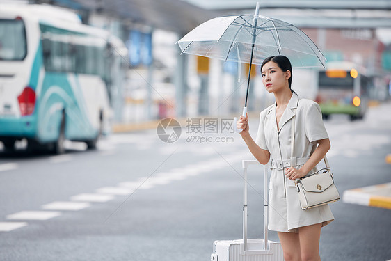 雨天在路边焦急等车的商务女性图片