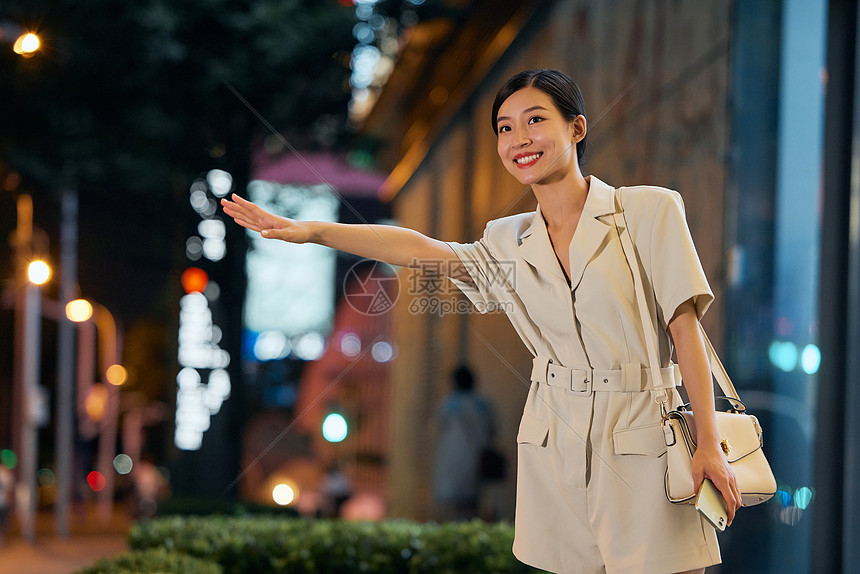 夜晚室外叫车的商务女性图片