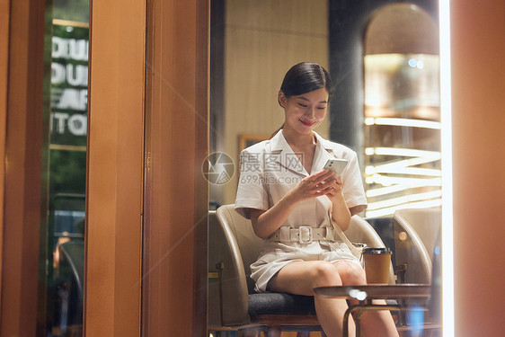 咖啡店内使用手机的商务女性图片