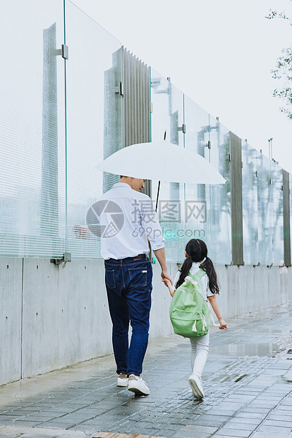 年轻父亲牵手接女儿放学图片