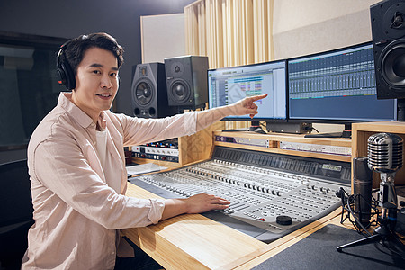 录音棚调控室男性调音师指向屏幕图片素材