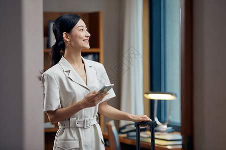 拖行李箱女孩拖着行李箱入住酒店的女白领背景