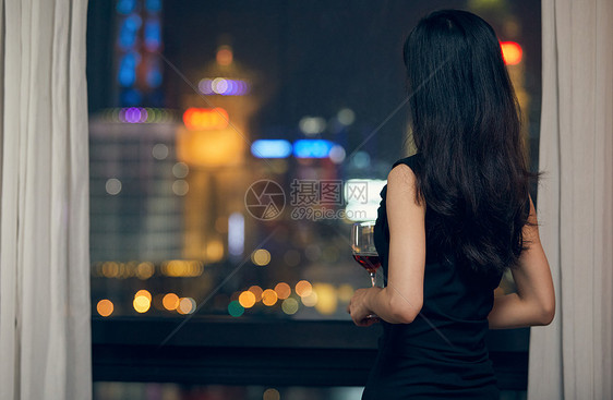 气质美女夜晚端着红酒杯背影图片