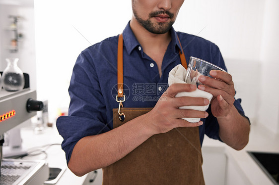 男性咖啡师擦拭玻璃杯特写图片