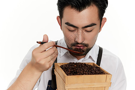 男性咖啡师低头闻咖啡豆图片