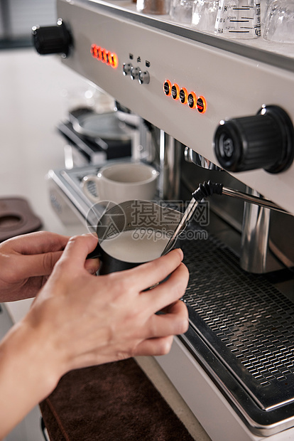 咖啡师用机器打奶泡特写图片