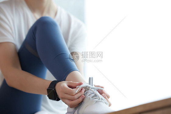 健身女性准备出门系鞋带特写图片