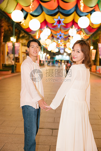 年轻情侣牵着手逛商店街图片