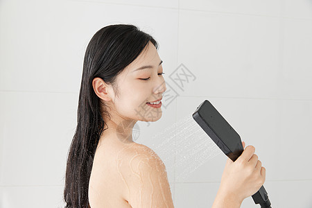 年轻女性手拿花洒淋浴背景图片