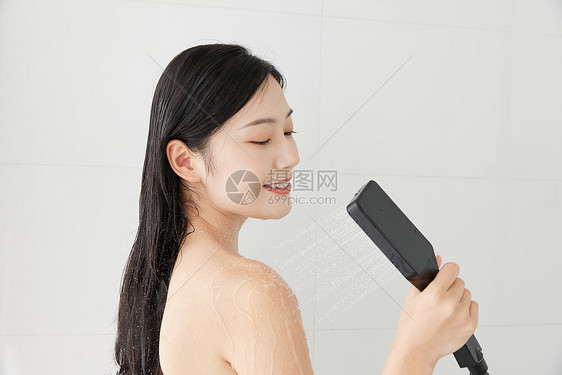 年轻女性手拿花洒淋浴图片