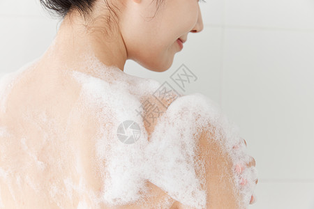 女性使用沐浴球洗澡背部特写图片