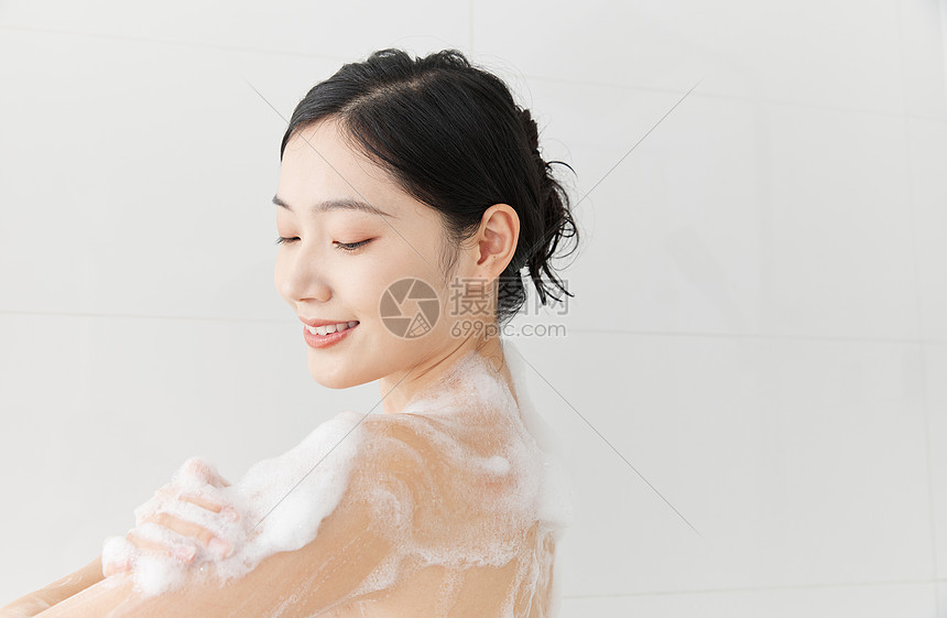 年轻女性使用沐浴球洗澡淋浴图片
