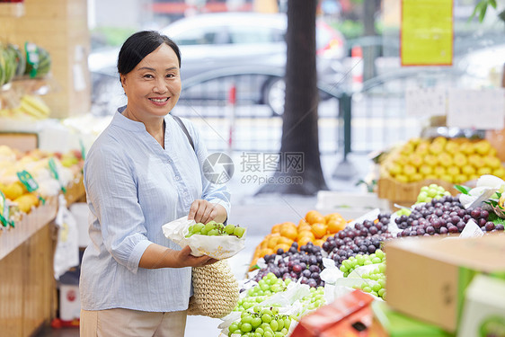 中年女性水果店购买葡萄图片