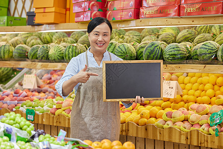 超市水果店店员手拿小黑板推销背景图片